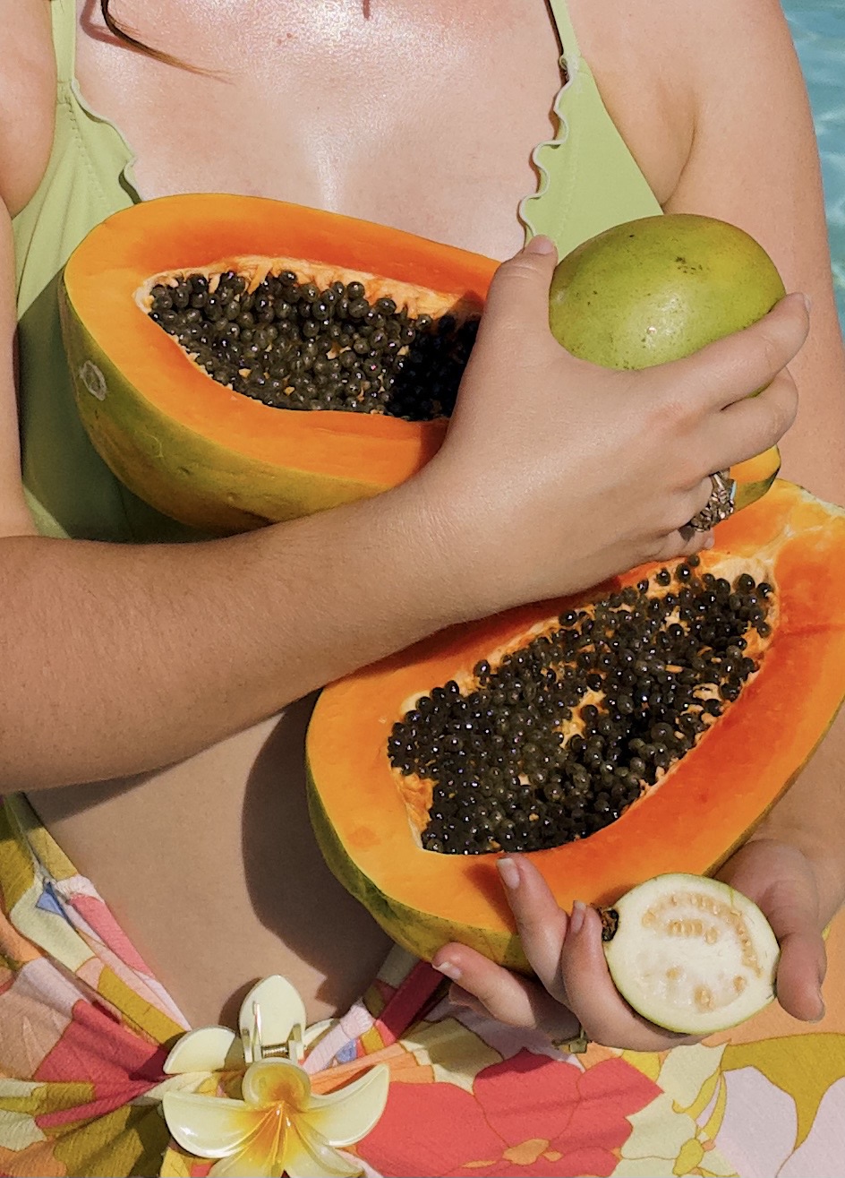 image of woman holding papaya and other fruits